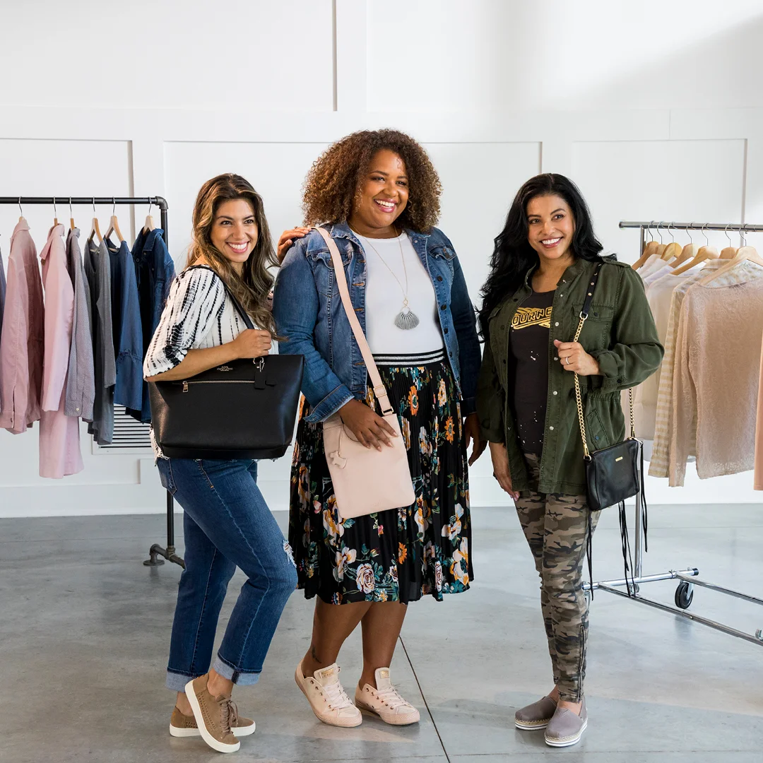 Three millennial women standing and modeling their fashions